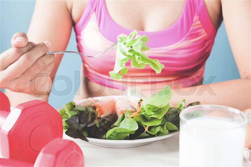 Female fitness eating fresh salad and milk, Healthy lifestyle concept, stock photo