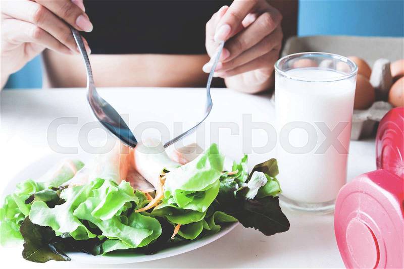 Female fitness eating fresh salad and milk, stock photo