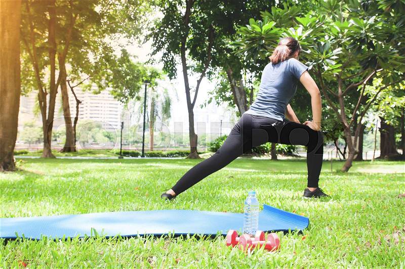 Asian woman in sport clothing working out in the park, Selective focus on sport equipment foreground, stock photo