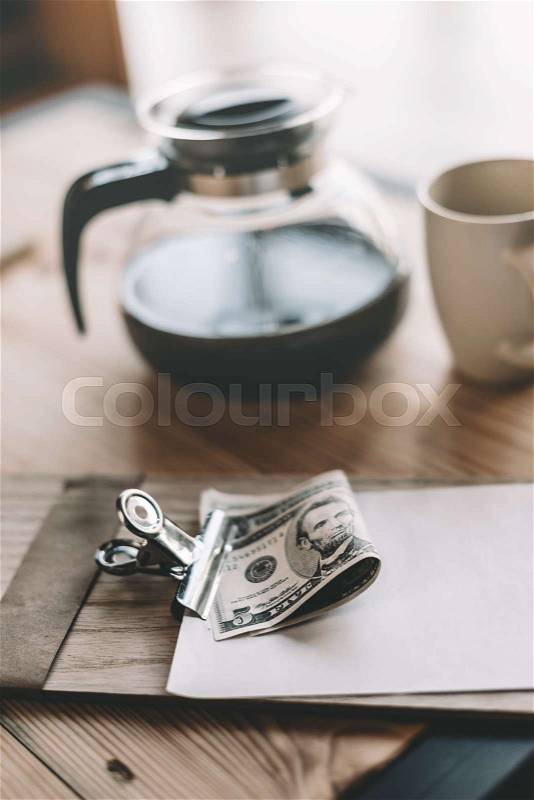 Bill, cash payment, glass kettle and cup of coffee on tabletop in cafe, stock photo