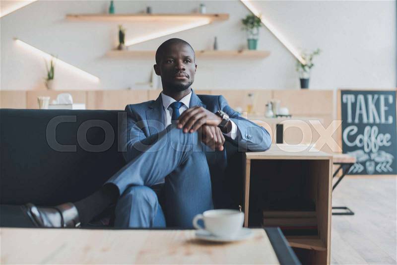 Confident african american businessman having coffee break in cafe , stock photo