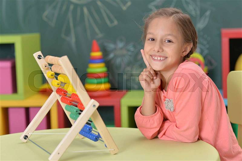 Cute little girl learning to count on abacus, stock photo