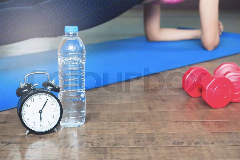 Workout and Healthy Lifestyle concept, Alarm clock, bottle of water and sport equipment, Yoga at home, stock photo