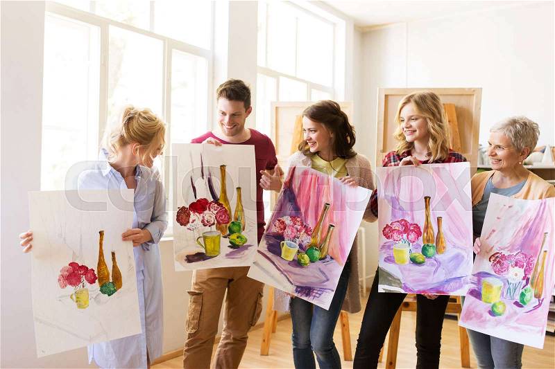 Painting, education and people concept - group of artists or students holding still life pictures at art school studio, stock photo
