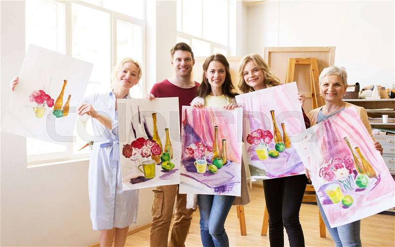 Painting, education and people concept - group of artists or students holding still life pictures at art school studio, stock photo