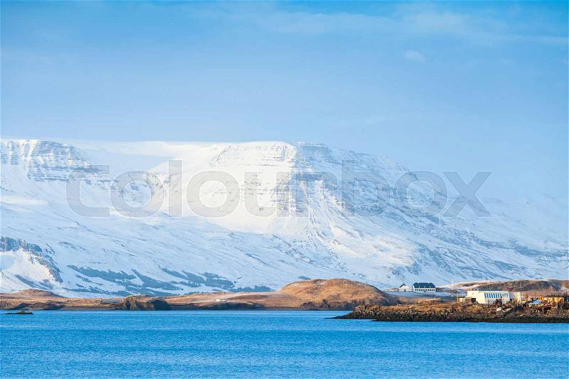 Icelandic coastal landscape with snowy mountains under blue sky. Reykjavik area, Iceland, stock photo