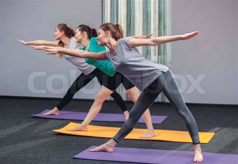 Three beautiful girls do yoga in the center of yoga and spa. The concept of a healthy lifestyle, stock photo
