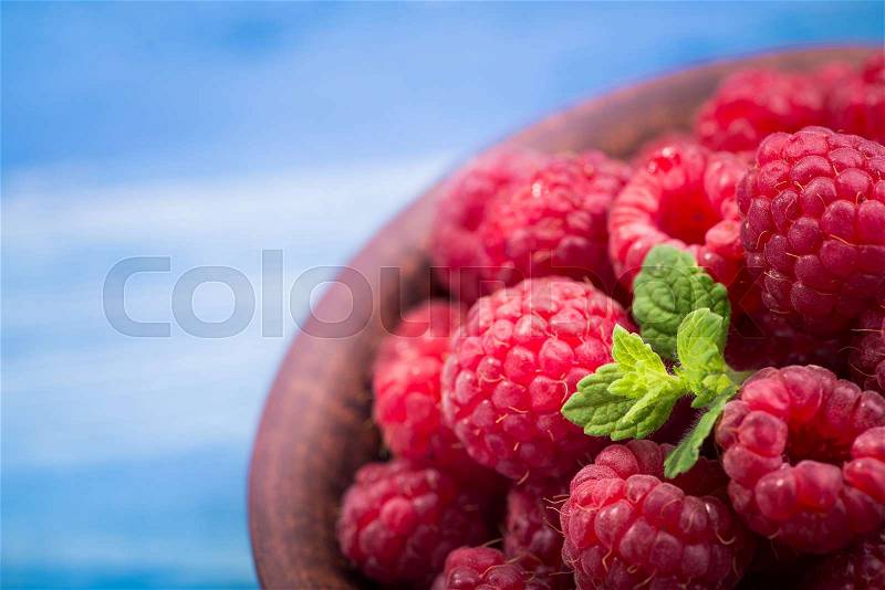 Sweet red dessert raspberry on blue rustic background, stock photo