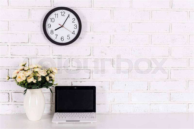 Workplace with modern laptop with blank screen and flowers at home or in office, stock photo
