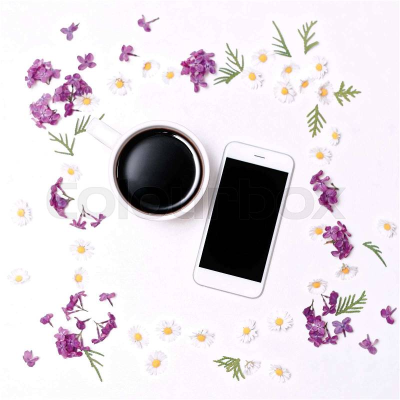 Lilac flower pattern with mobile phone and cup of coffee on the white table background. Flat lay, top view, stock photo