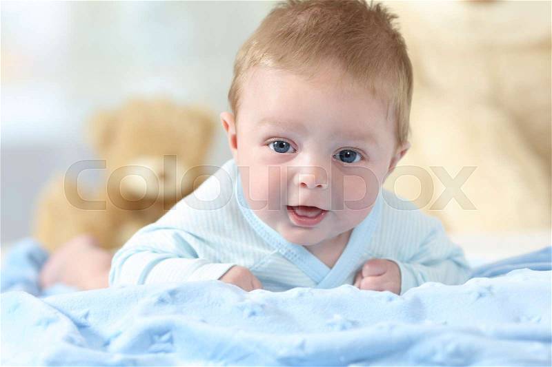 Front view portrait of a happy baby looking at you on a bed, stock photo