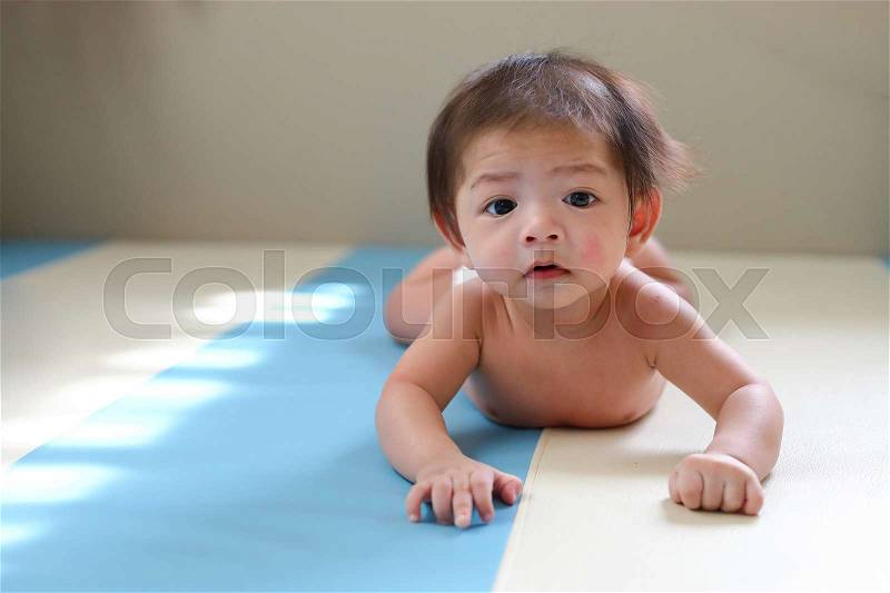 Adorable baby boy trying crawl clamber first time, cute asian child newborn 3 months happy relaxing in nursery room, little kid new member in family home, stock photo