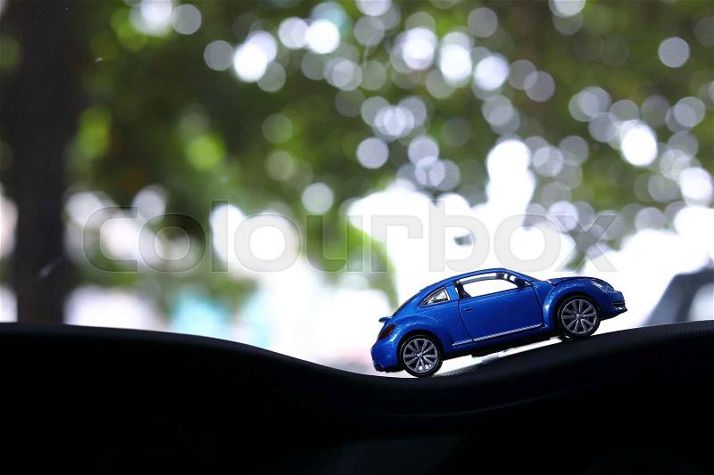 Toy car with bokeh green natural background, vehicle travel road trip in adventure nature destination, stock photo