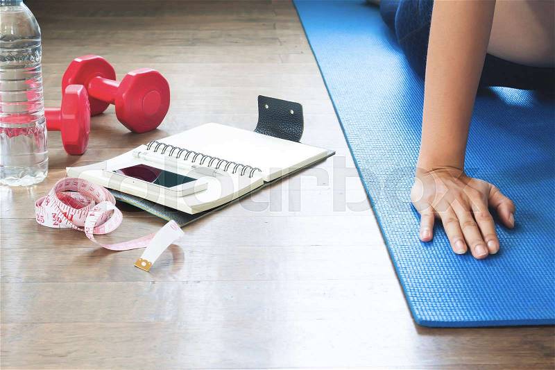 Sport equipments and healthy lifestyle accessories with woman doing yoga, stock photo
