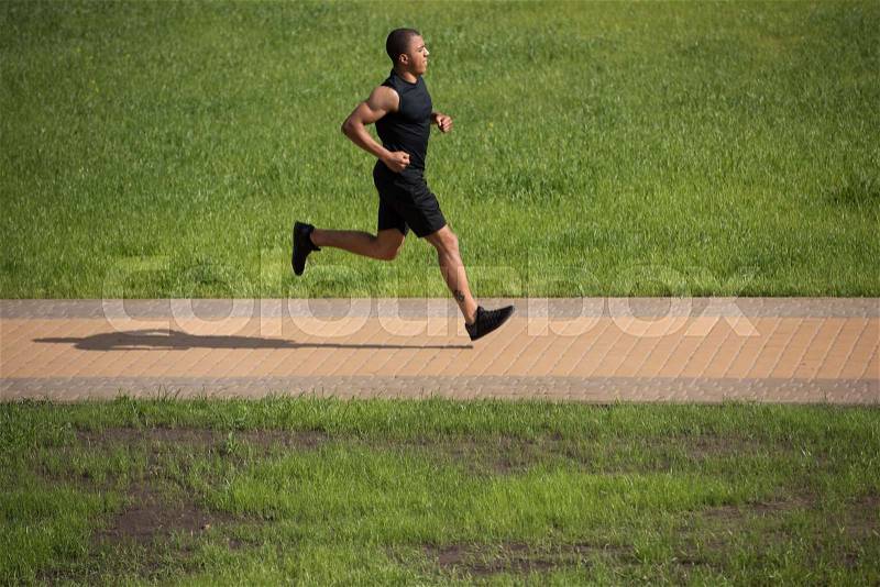 Side view of athletic young african american sportsman running in park, stock photo