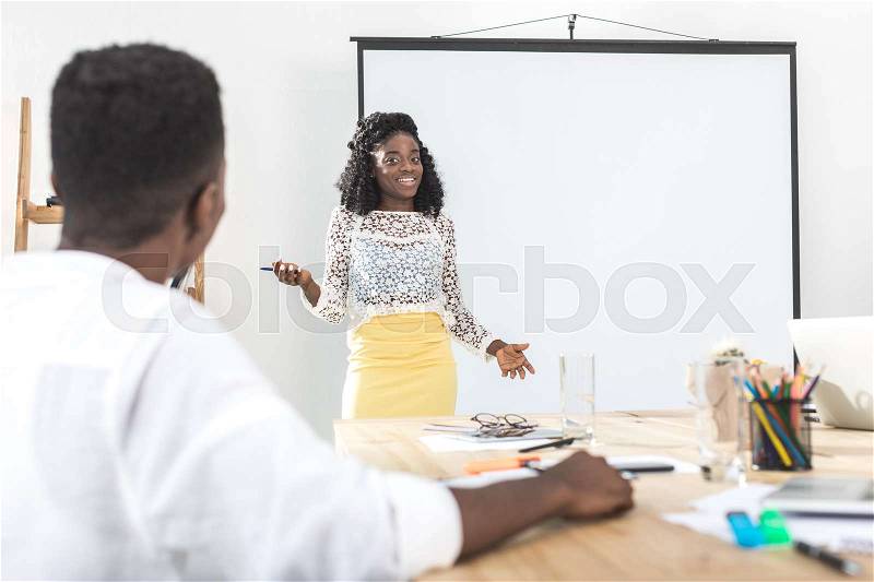 African american businesswoman presenting new business concept to at meeting, stock photo