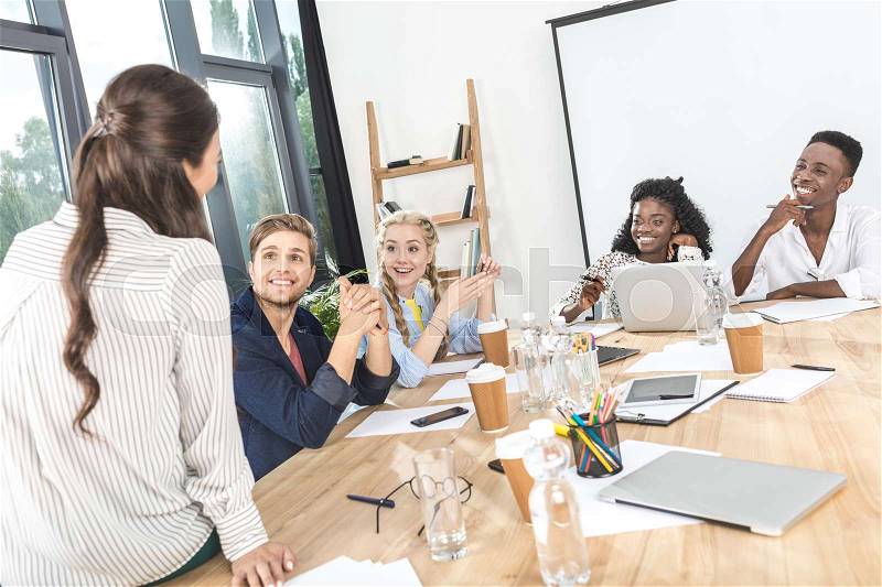 Young business team discussing business plan together during conference in office, stock photo