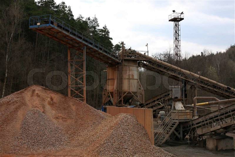 Stone quarry with silos, conveyor belts and piles of stones, stock photo