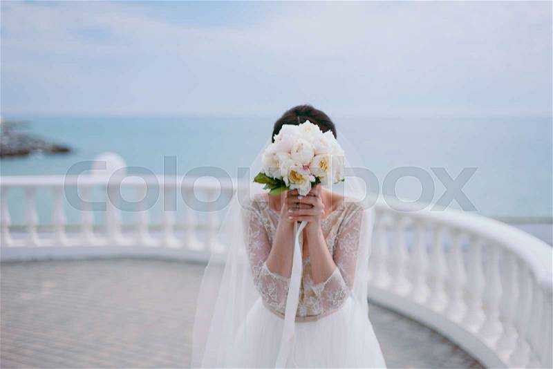 Bride holding big wedding bouquet on wedding ceremony, stock photo