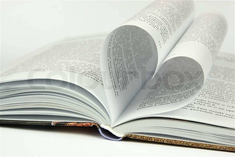 Open book and shape of the heart on a white background, stock photo