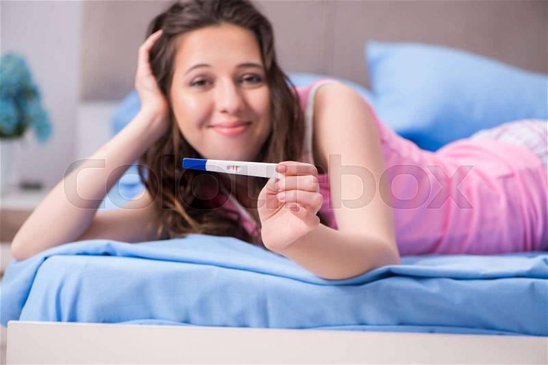 Woman with pregnancy results test, stock photo