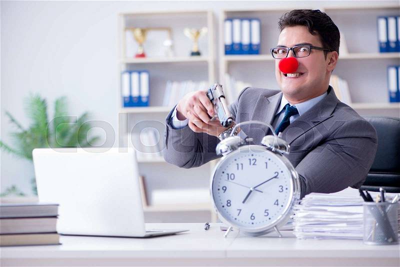 Clown businessman working in the office angry frustrated with a gun, stock photo