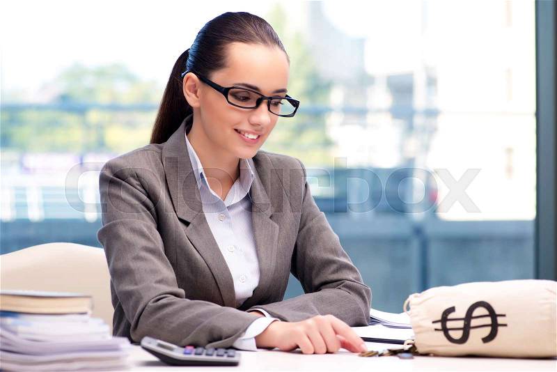 Businesswoman with money sack bag in office, stock photo