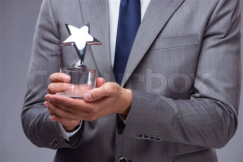 Businessman holding star award in business concept, stock photo