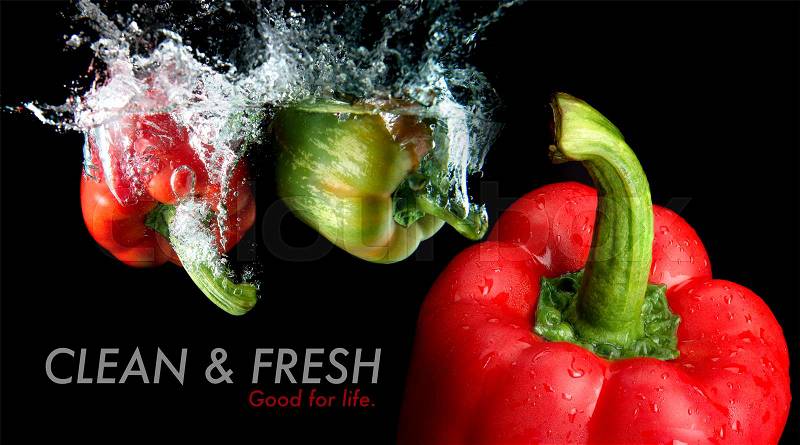 Splash water from water droping bell pepper mixed with focus another bell pepper in black background and sample text with studio lighting. in black background with studio lighting, stock photo