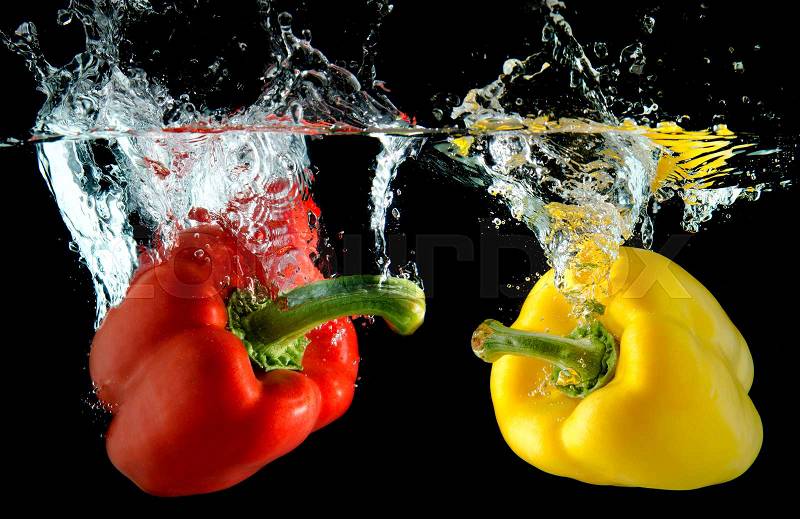 Splash water from water droping bell pepper in black background with studio lighting, stock photo