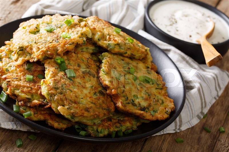 Freshly cooked Zucchini pancakes with sour cream close-up on the table. horizontal , stock photo