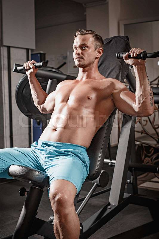The handsome fitness man weightlifting workout in gym, stock photo
