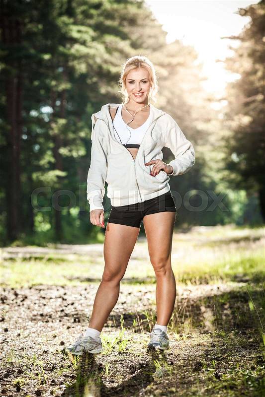 Young lady running on a rural road during sunset, stock photo