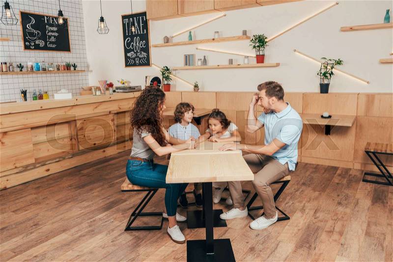 Beautiful happy young family in cafe with modern trendy interior, stock photo