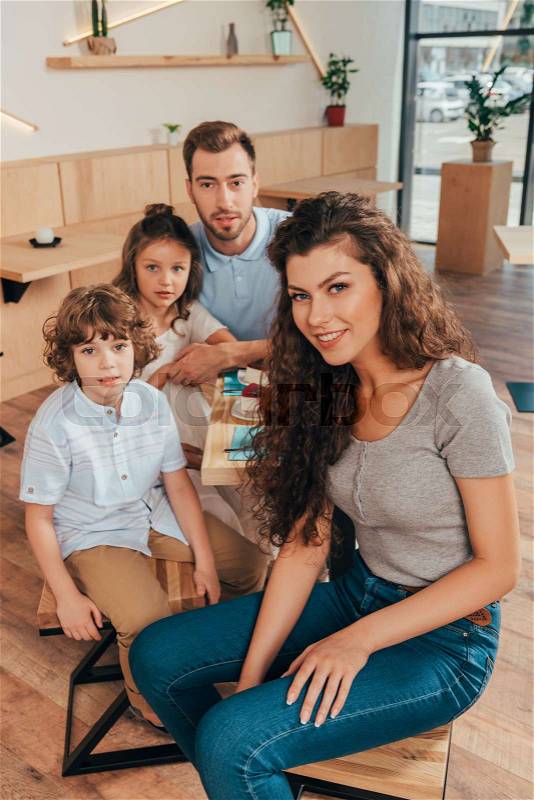 Beautiful young family in cafe with modern trendy interior, stock photo