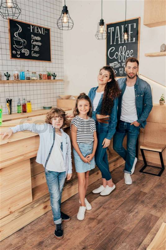 Beautiful happy young family in cafe at bar counter, stock photo