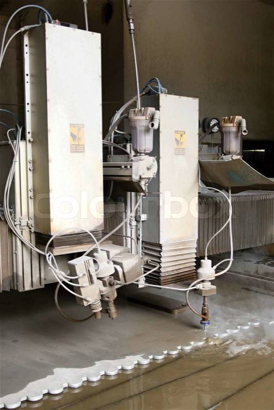 Machine using water pressure to cut through stainless steel materials, stock photo
