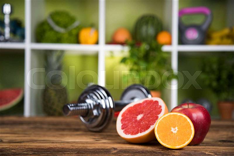Fitness concept with dumbbells and fresh fruits, stock photo