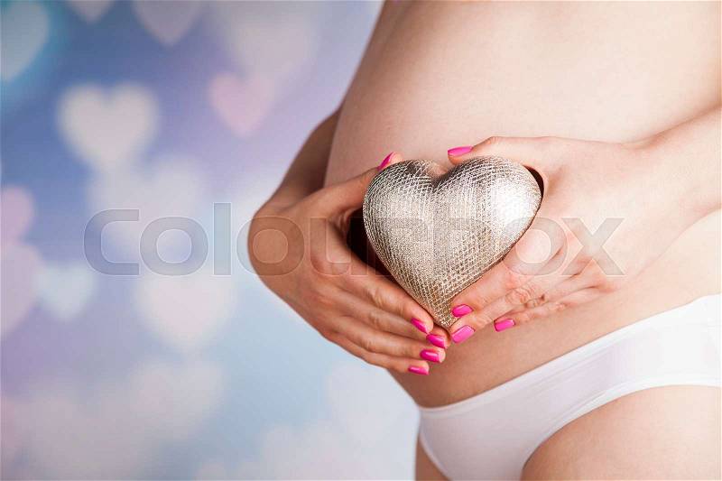 Pregnant woman loving heart her baby, stock photo