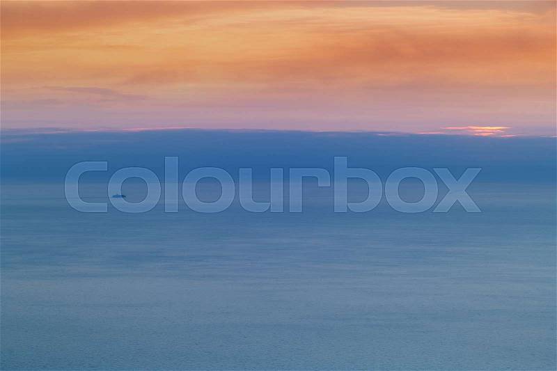 Vibrant colored sky and sea at dawn.Beautiful sunset over sea with horizon and ship in distance, stock photo