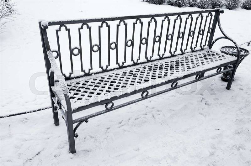 Outdoor metal bench covered with snow in winter park. St-Petersburg, Russia, stock photo