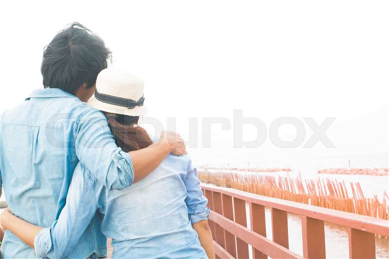 Happy asian couple in casual jeans hugging on wooden bridge by the sea, Summer travel, Happy lifestyle, stock photo