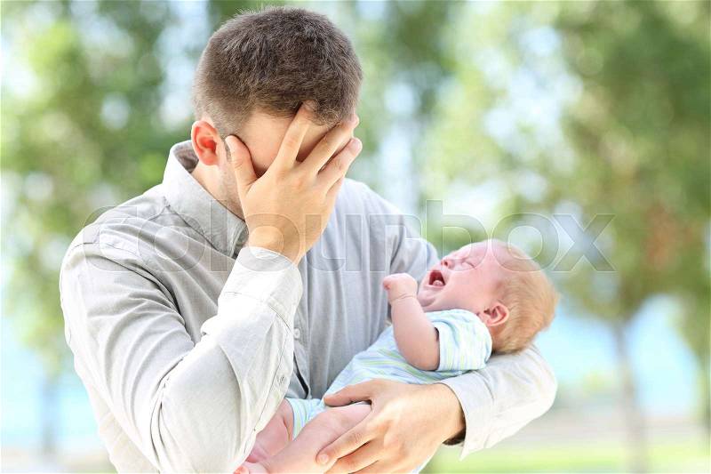 Worried father and baby crying outdoors, stock photo