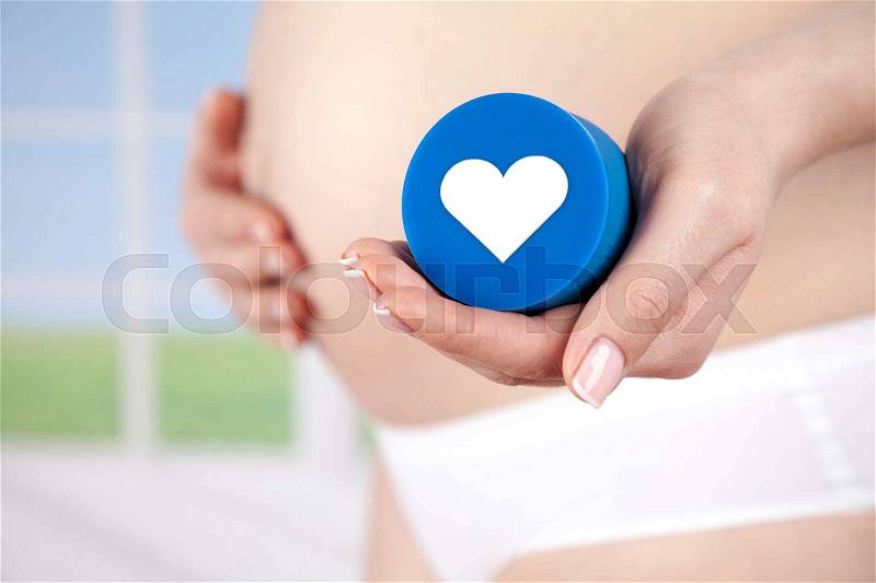 Pregnant woman loving heart her baby, stock photo