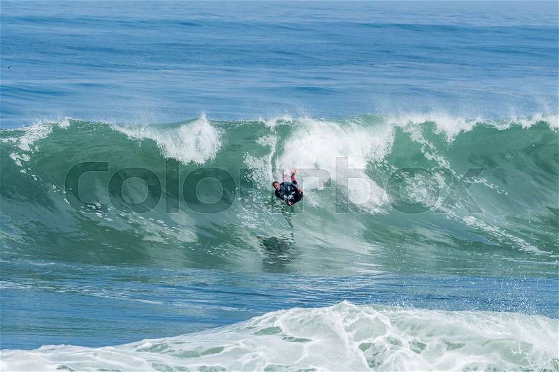 Bodyboarder in action on the ocean waves on a sunny day, stock photo