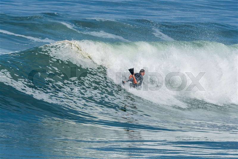 Bodyboarder in action on the ocean waves on a sunny day, stock photo