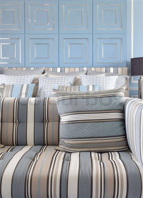 Light blue and light brown striped sofa set with classic blue wall, stock photo