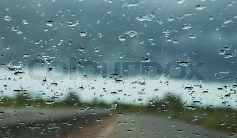 Raining drops on car front glass , stock photo
