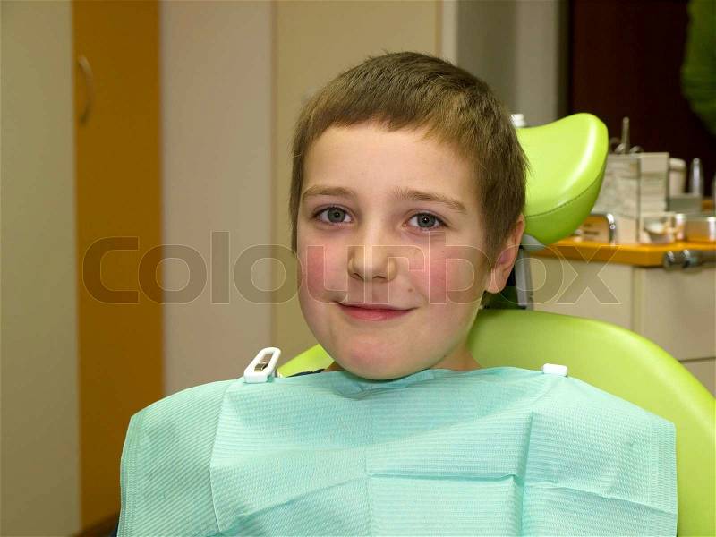 Young boy in dental chair waiting for examination, stock photo
