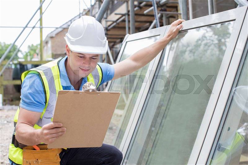 Construction Worker Preparing To Fit New Windows, stock photo